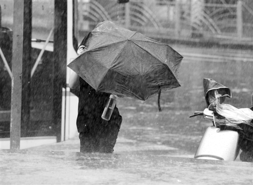 在上海闵行区,行人在风雨中前行